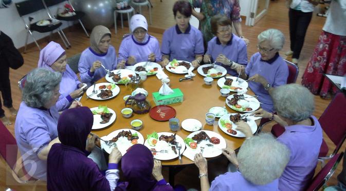 Oma Heni dan Oma Iva berkumpul bersama sesama lansia di Day Care Graha Ichsan. Mereka menyantap makan siang yang telah disediakan usai melakukan banyak kegiatan selama dua jam (Aditya Eka Prawira/Liputan6.com)