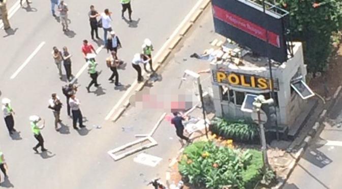 Petugas dan warga mencoba mendekati korban yang tergelatak di dekat pos polisi di depan Mal Sarinah, Jakarta, akibat sebuah ledakan, Kamis (14/1). Lalu lintas di Jalan MH Thamrin dekat lokasi kejadian menjadi sepi. (twitter.com/agung_budiono)