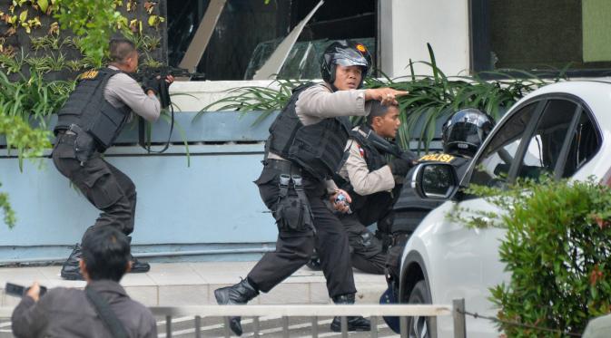 Polisi dari Densus Antiteror dan Gegana Polda Metro Jaya bersenjata laras panjang duntuk  mengambil posisi saat adu tembak dengan pelaku ledakan di pospol Sarinah, Jakarta, Kamis (14/1). (AFP PHOTO/Bay Ismoyo)