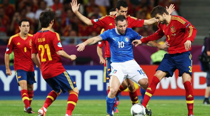 ara pemain tim nasional Spanyol mencoba merebut bola dari kaki pemain Italia, Antonio Cassano, pada partai final Piala Eropa 2012, di Olympic Stadium, 1 Juli 2012. (UEFA)