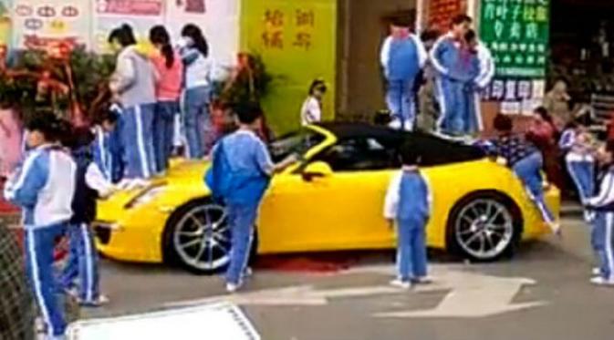 Mobil sport berkelir kuning ini dipanjati dan diinjak-injak oleh bocah yang bermain.