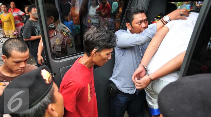 Empat orang yang diduga menjadi bandar narkoba diamankan petugas Sat Reskrim Polres Metro Jakarta Timur, Kamis (21/1). Aparat gabungan lakukan penggeledahan dan mencari pelaku tersangka pengeroyokan di kampung Berlan. (Liputan6.com/Yoppy Renato)