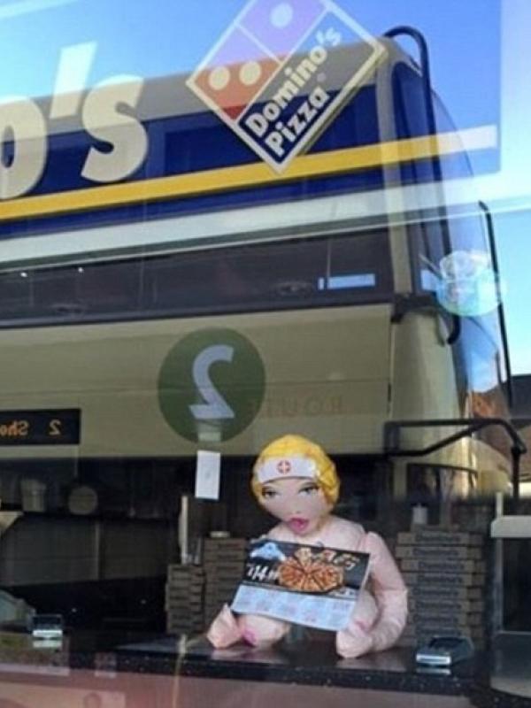 Boneka seks terlihat di jendela salah satu kedai pizza di Shoreham, Britania Raya, Selasa (19/1). | via: Daily Mail