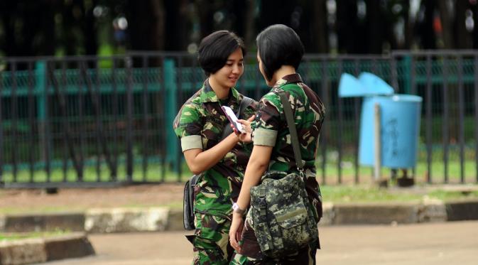  Prajurit wanita TNI melakukan komunikasi saat berpatroli di sekitar kawasan Stadion GBK Jakarta, Minggu (24/1/2016).