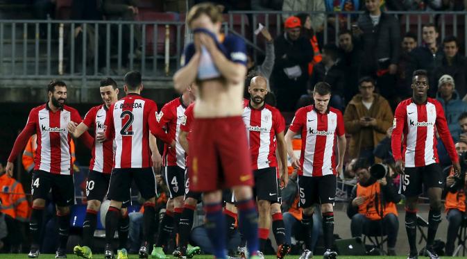 Ivan Rakitic tampak kecewa saat para pemain Athletico Bilbao merayakan gol ke gawang Barcelona pada leg kedua perempat final Copa del Rey di Camp Nou, Kamis (28/1/2016). (Liputan6.com/ REUTERS/Albert Gea)