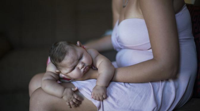Gleice Kelly da Silva memangku putrinya, Maria Giovanna, yang lahir dengan mikrosefali. (Via: npr.org)