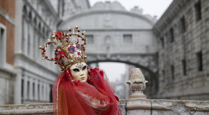 Peserta menggunakan kostum dan topeng saat mengikuti Karnaval Venesia di Piazza San Marco, Italia, Sabtu (30/1). Dalam acara tahunan ini, peserta mengenakan kostum ala Venesia abad ke-18 dan topeng-topeng unik menutupi wajah (REUTERS/Alessandro Bianchi)