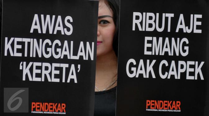 Model memperlihatkan spanduk saat aksi ruwat di Kawasan Bundaran Patung Kuda, Jakarta (1/2/2016). Dalam aksi tersebut mereka berharap Partai Golkar agar dapat bersatu kembali. (Liputan6.com/Gempur M Surya)