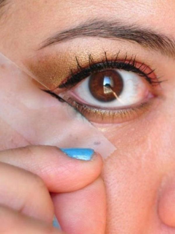  Membuat eyeliner model mata kucing pakai selotip. (Via: pinterest.com)