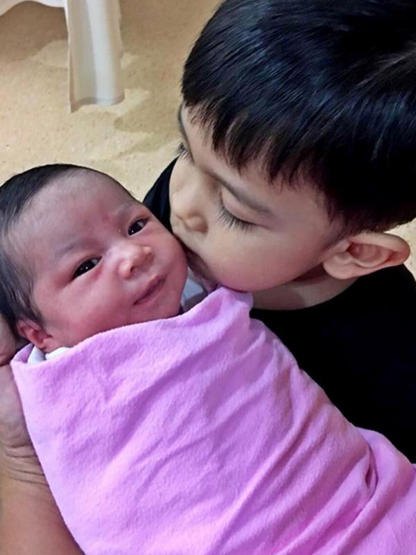 Anak pertama Intan Nuraini, Razi, mencium sang adik. [Foto: Instagram]
