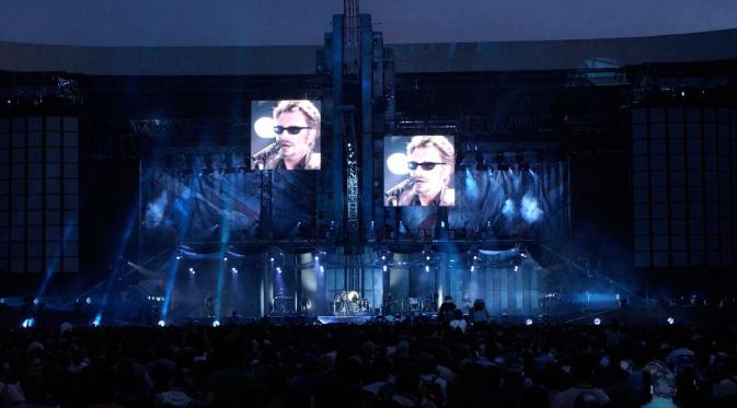 Penyanyi terkenal asal Prancis, Johnny Hallyday, saat menggelar konser di Parc des Princes, 10 Juni 2003. (AFP/Bertrand Guay)