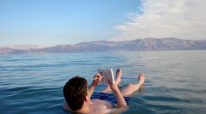 Mengapung, sensasi yang bisa dicicip di Laut Mati. (curiousmindbox.com)