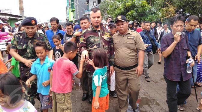 Sejumlah anak berebut mencium tangan dan bersalaman dengan musisi Ahmad Dhani saat tiba di  lokalisasi Kalijodo, Penjaringan, Jakarta, Senin (15/2). Suami dari Mulan Jameela itu mendatangi Kalijodo dikawal Banser Nahdlatul Ulama (NU). (Foto : Muslim AR)