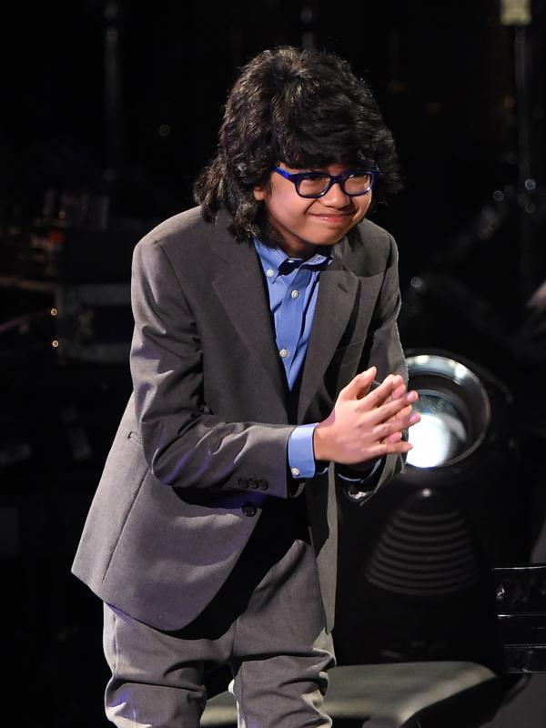 Pianis muda Indonesia, Joey Alexander (12)  memberi salam kepada penonton saat tampil di panggung Grammy Awards 2016 di Los Angeles, Senin (15/2). Joey tidak menang, tetapi namanya akan terukir dalam catatan sejarah musik Indonesia. (AFP PHOTO/Robyn BECK)