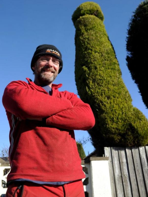 Chris Bishop yang juga seorang dokter bedah membuat pohon bentuk penis depan rumahnya. (Via: Mirror.co.uk)