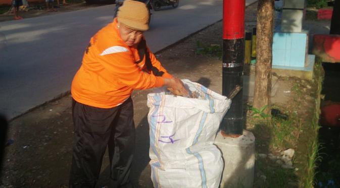 Dalam rangka merayakan Hari Peduli Sampah Nasional, seorang nenek di Makassar, mengumpulkan sampah yang berceceran di jalan. (Liputan6.com/Eka Hakim)