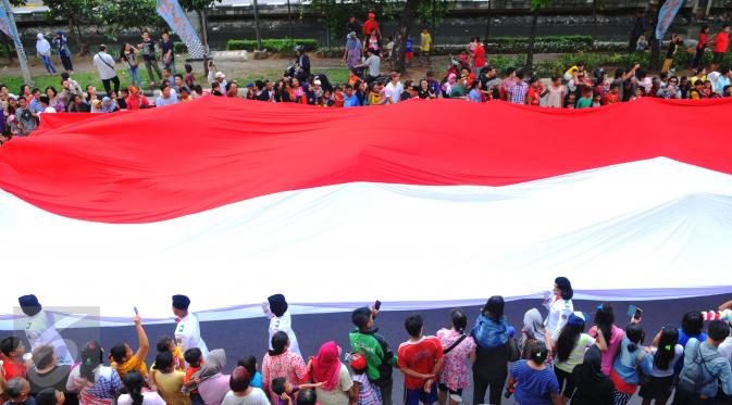 Bendera merah putih berukuran besar diarak saat karnaval perayaan Cap Go Meh di Glodok, Jakarta, (21/2). Perayaan yang merupakan rangkaian terakhir perayaan Imlek itu diikuti 1477 peserta dengan menampilkan berbagai kesenian. (Liputan6.com/Faisal R Syam)