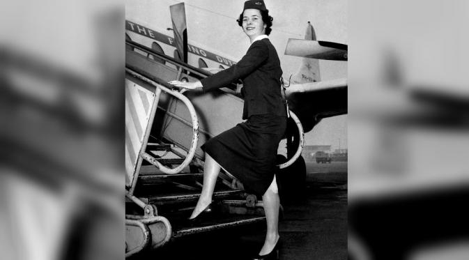Seorang Pramugari KLM di tahun 1959 memperlihatkan seragamnya dengan panjang rok persis di bawah lutut dan belahan di belakangnya (Foto: Alamy Stock Photo).
