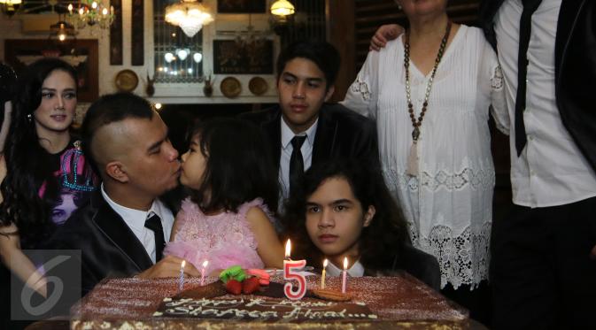 Ahmad Dhani mencium Safeea Ahmad disela perayaan ulang tahun bocah lima tahun itu di kediamannya di Pondok Indah, Jakarta, Rabu (24/2). Acara yang diadakan sederhana ini juga digunakan untuk sesi foto keluarga Ahmad Dhani. (Liputan6.com/Herman Zakharia)