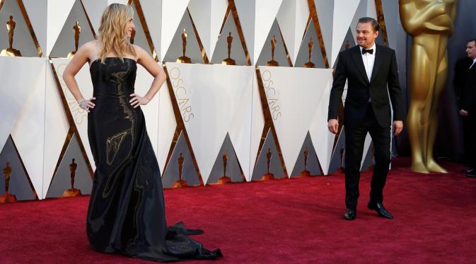 Leonardo DiCaprio, nominator kategori Best Actor, ketika mengamati Kate Winslet, nominator kategori Best Supporting Actress, yang tengah berpose di red carpet Piala Oscar 2016 di Dolby Theatre, Hollywood, California, Minggu (28/2) (REUTERS/Lucy Nicholson)