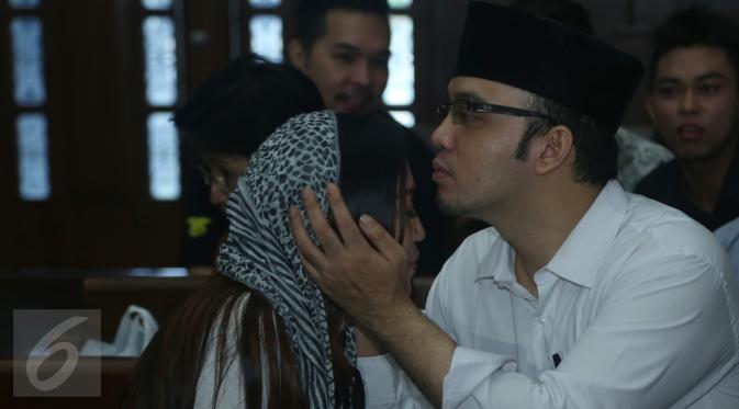 Tersangka Sandy Tumiwa mencium istrinya saat akan menjalani sidang di Pengadilan Jakarta Pusat, Selasa (1/3/2016). Sidang penipuan dengan tersangka Sandy Tumiwa kembali digelar dengan agenda mendengarkan saksi Annisa Bahar. (Liputan6.com/Herman Zakharia)