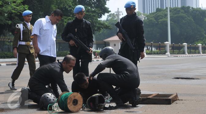 Pasukan katak TNI AL mempersiapkan peralatan untuk menyusuri gorong-gorong di depan Istana Merdeka, Jakarta, Kamis (3/3). Pasukan katak ini dilibatkan menyusul temuan kulit kabel yang sebelumnya ditemukan di gorong-gorong. (Liputan6.com/Gempur M Surya)