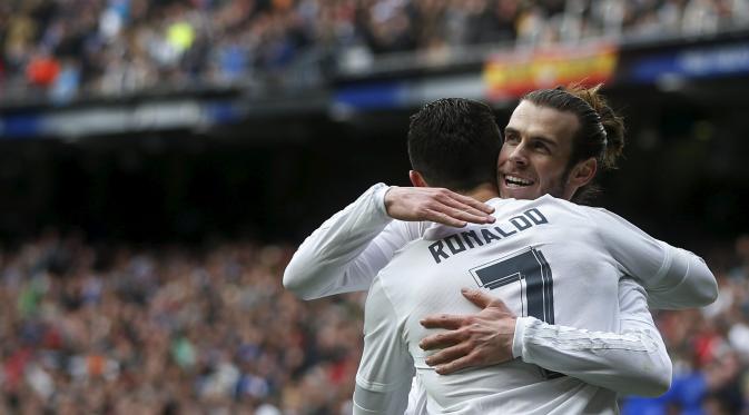 Cristiano Ronaldo (tampak belakang) mendapat ucapan selamat dari Gareth Bale usai merobek jala Celta Vigo, pada laga lanjutan La Liga 2015-2016, di Stadion Santiago Bernabeu, Sabtu (5/3/2016) malam WIB. (AFP). 
