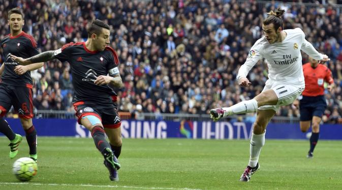 Pemain Real Madrid, Gareth Bale melakukan tembakan ke arah gawang Celta de Vigo saat dihadang para pemain lawan pada lanjutan La Liga Spanyol di Stadion Santiago Bernabeu , Madrid, Sabtu (5/3/2016). (AFP/Gerard Julien)
