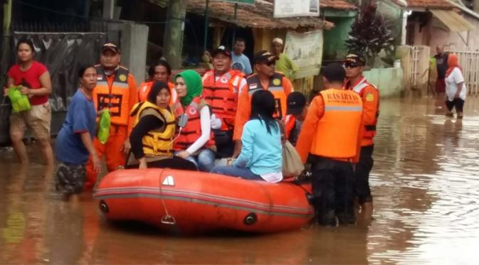Arzetti Bilbina (berkerudung hijau) menolong korban bencana banjir di Desa Dayeuh Kolot, Kelurahan Bale Endah, Kabupaten Bandung.
