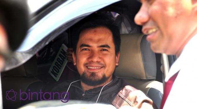 Penyanyi dangdut yang tersangkut kasus pelecehan seksual Saipul Jamil tersenyum di mobil saat menjalani rekonstruksi. (Adrian Putra/Bintang.com)