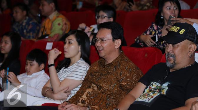 Gubernur DKI Jakarta Basuki T Purnama alias Ahok bersama istri saat menyaksikan film Comic 8 di Djakarta Theatre, Jakarta, Jumat (18/3). Film yang disutradarai Anggy Umbara ini meraih penghargaan Poster Film Terbaik. (Liputan6.com/Herman Zakharia)