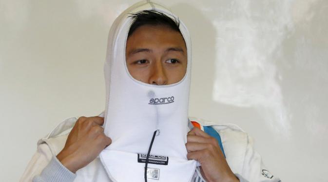 Ekspresi pebalap Manor Racing asal Indonesia, Rio Haryanto, saat memakai pengaman api jelang latihan bebas ketiga F1 GP Australia di Sirkuit Albert Park, Australia, Sabtu (19/3/2016). (Reuters/Brandon Malone)