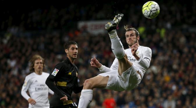 Aksi gelandang Real Madrid, Gareth Bale (kanan) menendang bola pada pertandingan melawan Sevilla di Liga Spanyol di Stadion Santiago Bernabeu (21/3). Real Madrid menang besar atas Sevilla dengan skor 4-0. (REUTERS/Sergio Perez)