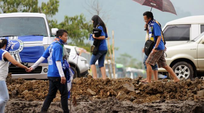 Bobotoh-bobotoh Persib rela melintasi jalanan becek demi mendukung Persib Bandung.