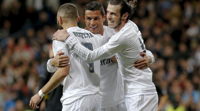 Gareth Bale dan Cristiano Ronaldo berpelukan setelah Karim Benzema mencetak gol ke gawang Sevilla, Minggu (20/3/2016). (EPA/Jason Powell)