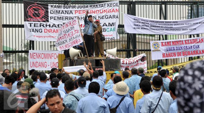 Ribuan Supir Taksi melakukan demo di depan Gedung DPR/MPR, Jakarta, Selasa (22/3). Selain melakukan demo, supir taksi tersebut melakukan sweeping ke supir taksi yang beroperasi di dalam tol dan membakar ban. (Liputan6.com/Johan Tallo)