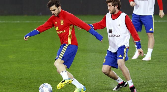   Gelandang Timnas Spanyol, Cesc Fabregas melakukan penguasaan bola, dibayangi Sergi Roberto, pada sesi latihan jelang lawan Italia, di Stadion Friuli, Udine, kemarin. Roberto menjadi pemain debutan di kubu La Furia Roja.  (Reuters/Alessandro Garofalo)