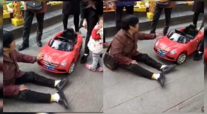 Seorang wanita tua minta dipanggilkan ambulans setelah ditabrak mobil mainan yang dikendarai anak kecil di Chongqing, China. (shanghaiist)