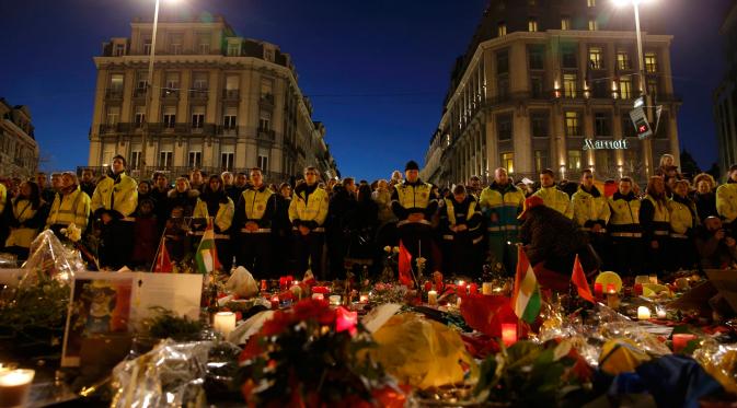 Petugas keamanan setempat juga ikut berkumpul di Place de la Bourse untuk mendoakan korban yang tewas pada serangan bom hari beberapa hari lalu, Brussels, Belgia, 25 Maret 2016. (Reuters/ Christian Hartmann).