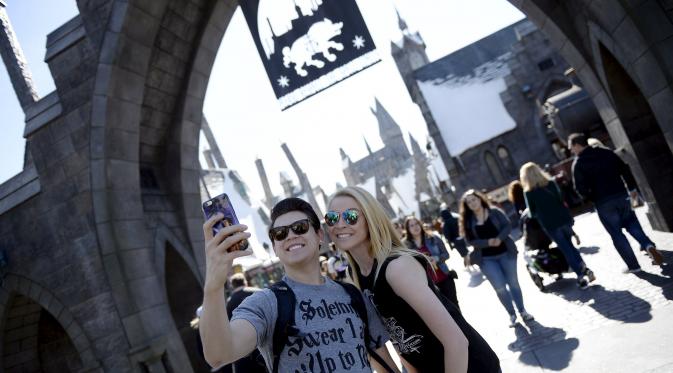 Pengunjung berselfie sebelum memasuki desa Hogsmeade dalam soft opening dan tur media taman bermain bertemakan "The Wizarding World of Harry Potter" di Universal Studios.