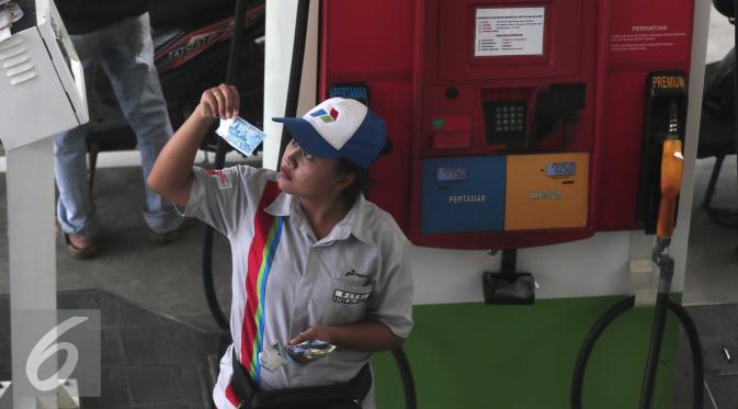 Petugas mengecek uang di SPBU di Jakarta, Selasa (29/3). Mengingat harga minyak dunia sudah mulai merangkak naik di level USD40 per barel. Sehingga ada kemungkinan harga BBM naik pada Juli mendatang. (Liputan6.com/Angga Yuniar)