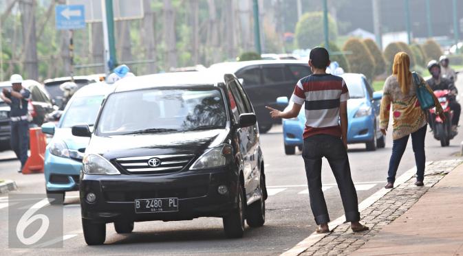 Joki 3 in 1 menawarkan jasa tumpangan kepada kendaraan roda empat di Senayan, Jakarta, Selasa (29/3). Gubernur DKI Jakarta Ahok berencana menghapus kebijakan 3 in 1 di jalan-jalan protokol. (Liputan6.com/Immanuel Antonius)