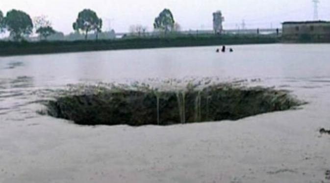 Bukan rumah, mobil atau gedung tinggi yang ditelannya. Kali ini sinkhole atau sebuah lubang raksasa muncul di kolam ikan milik seorang petani di Kota Baisha, Provinsi Guangxi, kawasan China Selatan.(Shanghaiist.com)