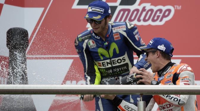 Marc Marquez dan Valentino Rossi saling semprot sampanye di podium juara MotoGP Argentina di Sirkuit Autodromo Termas de Rio Hondo. (AFP/Juan Mabromata)