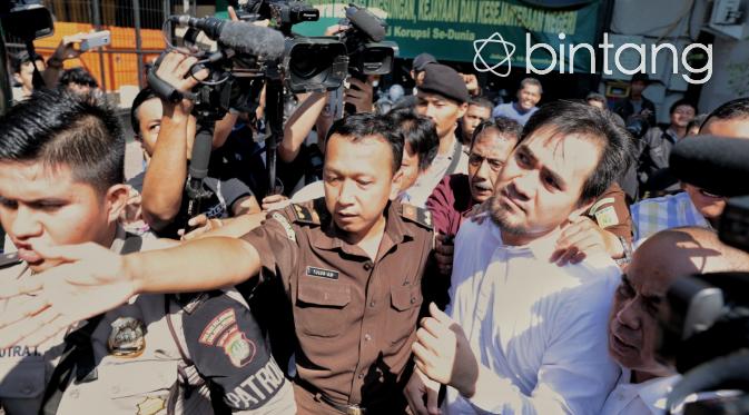 Saipul Jamil berusaha keluar dari kerumunan wartawan dan massa menuju mobil tahanan. (Adrian Putra/Bintang.com)