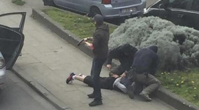 Petugas kepolisian Belgia saat menangkap tersangka penyerangan di Paris Mohamed Abrini di Anderlecht, dekat Brussel, Belgia, Jumat (8/4). Mohamed Abrini tak berkutik ketika dibekuk pasukan khusus Belgia. (REUTERS/Sebastien Dana-Kamran)