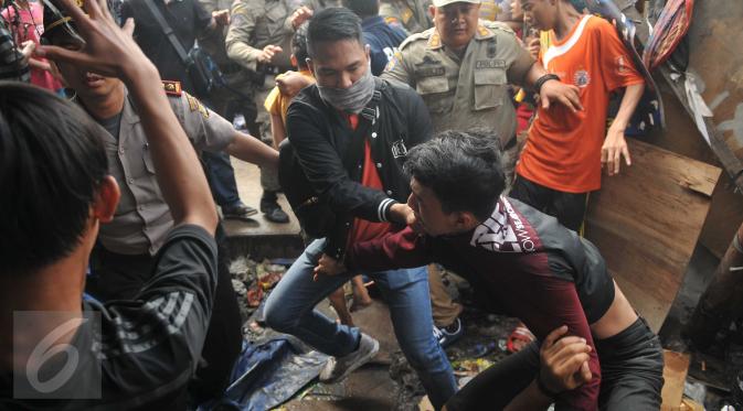Seorang remaja dibawa paksa oleh aparat keamanan saat penggusuran di kawasan Pasar Ikan, Penjaringan, Jakarta, Senin (11/4). Bentrokan sempat terjadi antara petugas dan warga yang menolak penggusuran di kawasan tersebut (Liputan6.com/Gempur M Surya)