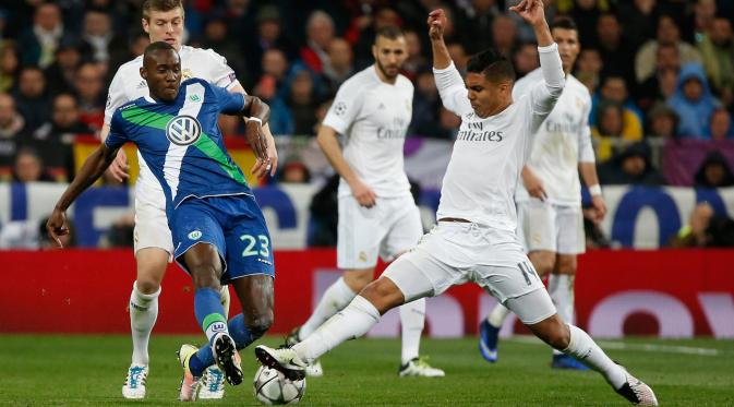 Gelandang Real Madrid, Casemiro (kanan) berebut bola dengan gelandang Wolfsburg, Josuha Guilavogui di leg kedua liga Champions di Santiago Bernabeu, Spanyol (13/4). Madrid menang atas Wolfsburg dengan skor 3-0. (Reuters/Sergio Perez).