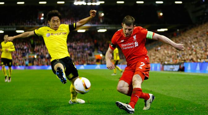 Gelandang Liverpool, James Milner berusaha mengumpan bola dari kawalan gelandang Dortmund, Shinji Kagawa di leg kedua Liga Europa di stadion Anfield, Inggris, (15/4). Liverpool menang dramatis atas Dortmund dengan skor 4-3. (Reuters/Darren Staples)