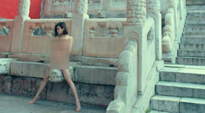 Seorang wisatawan nekat berfoto telanjang mengangkangi kepala patung naga di Kota Terlarang, Beijing, pada Mei 2015. (Sumber Shanghaiist.com)